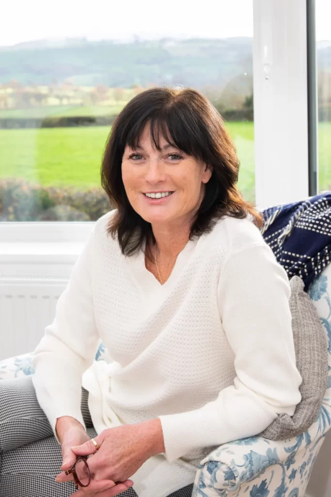 Cerys the owner of Sunsets and Stars Shepherd's hut and holiday cottage near the cottage bay window